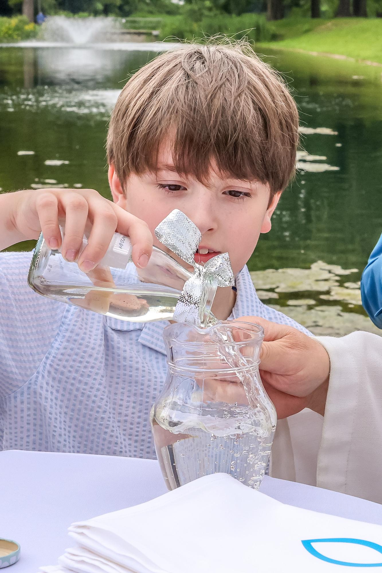 Ferdinand füllt das Wasser, das er morgens aus der Schwalm geschöpft hat, in den Krug. Damit wird der Achtjährige getauft.