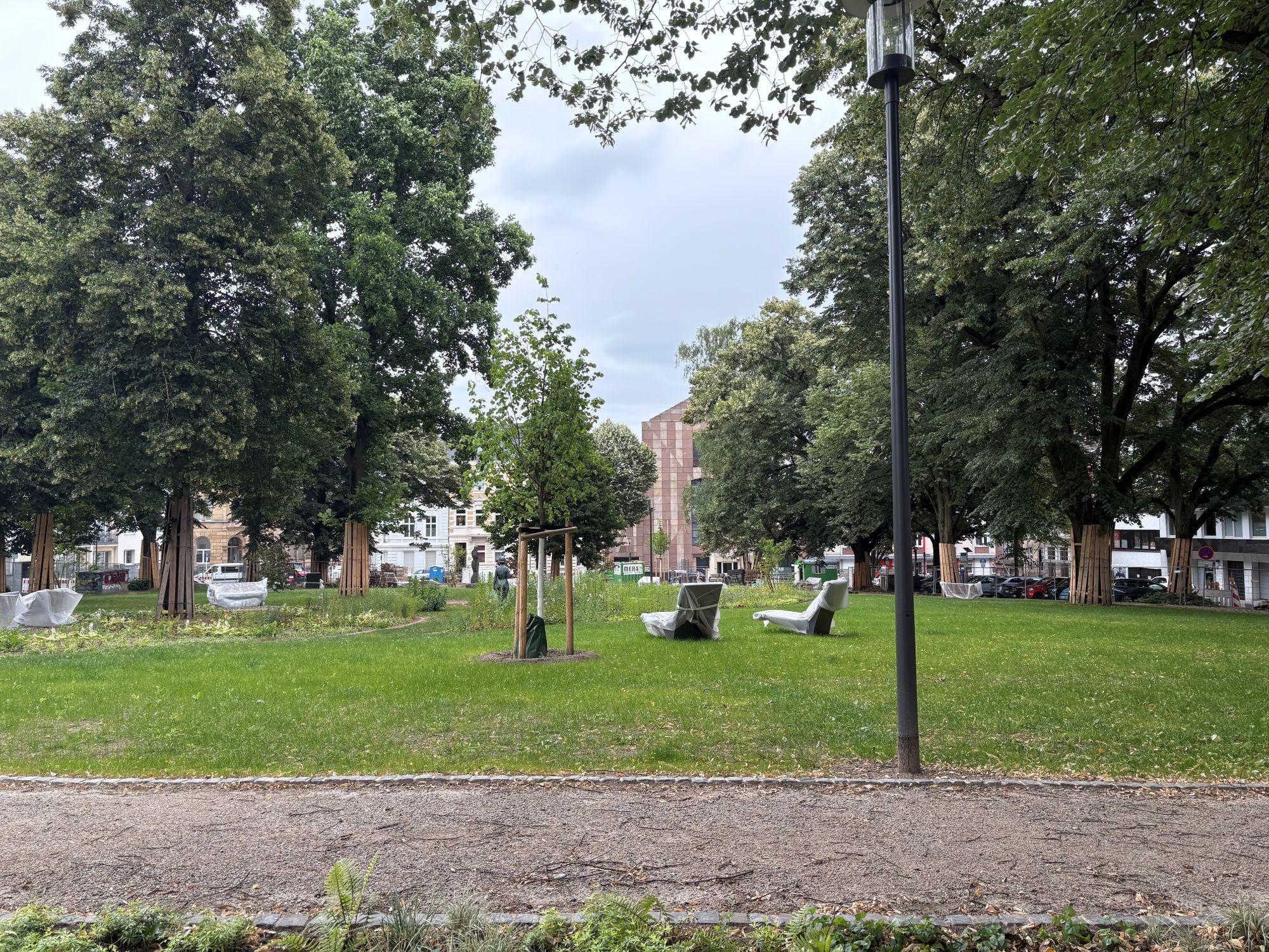 Die Grünanlage des Adenauerplatzes wird derzeit neu gestaltet. Im hinteren Teil des Bildes ist die Albertuskirche erkennbar.
